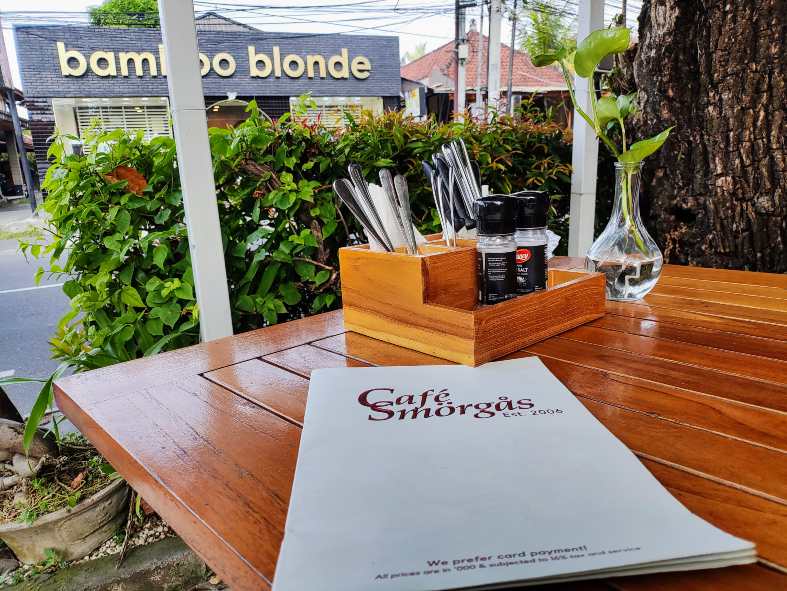 outdoor setting with a menu on the table at Cafe smorgus
