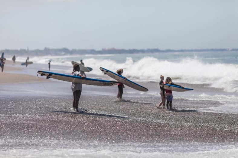 young people lined up on the beach in Kuta for a surfing lesson