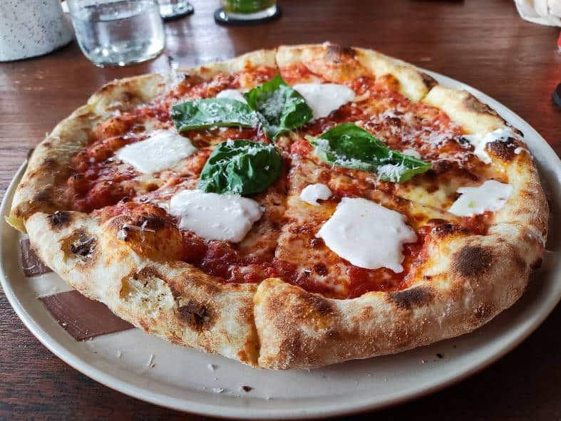 a pizza on the plate at shotgun social in Sanur