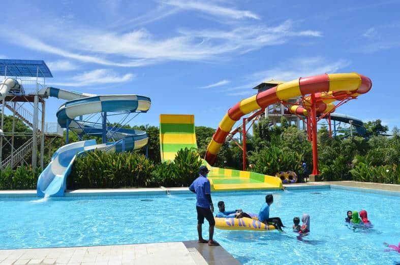 Families playing in the pool at the bottom of the waterslide in Bali
