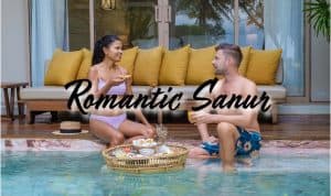 a couple on a romantic sanur getaway sitting by there swimmibng pool
